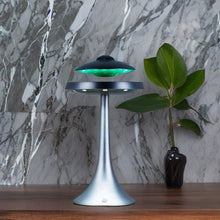 Indlæs billede til gallerivisning Ægte ufo bluetooth speaker fremvist på et skrivebord hvor man kan se ufoen svæve